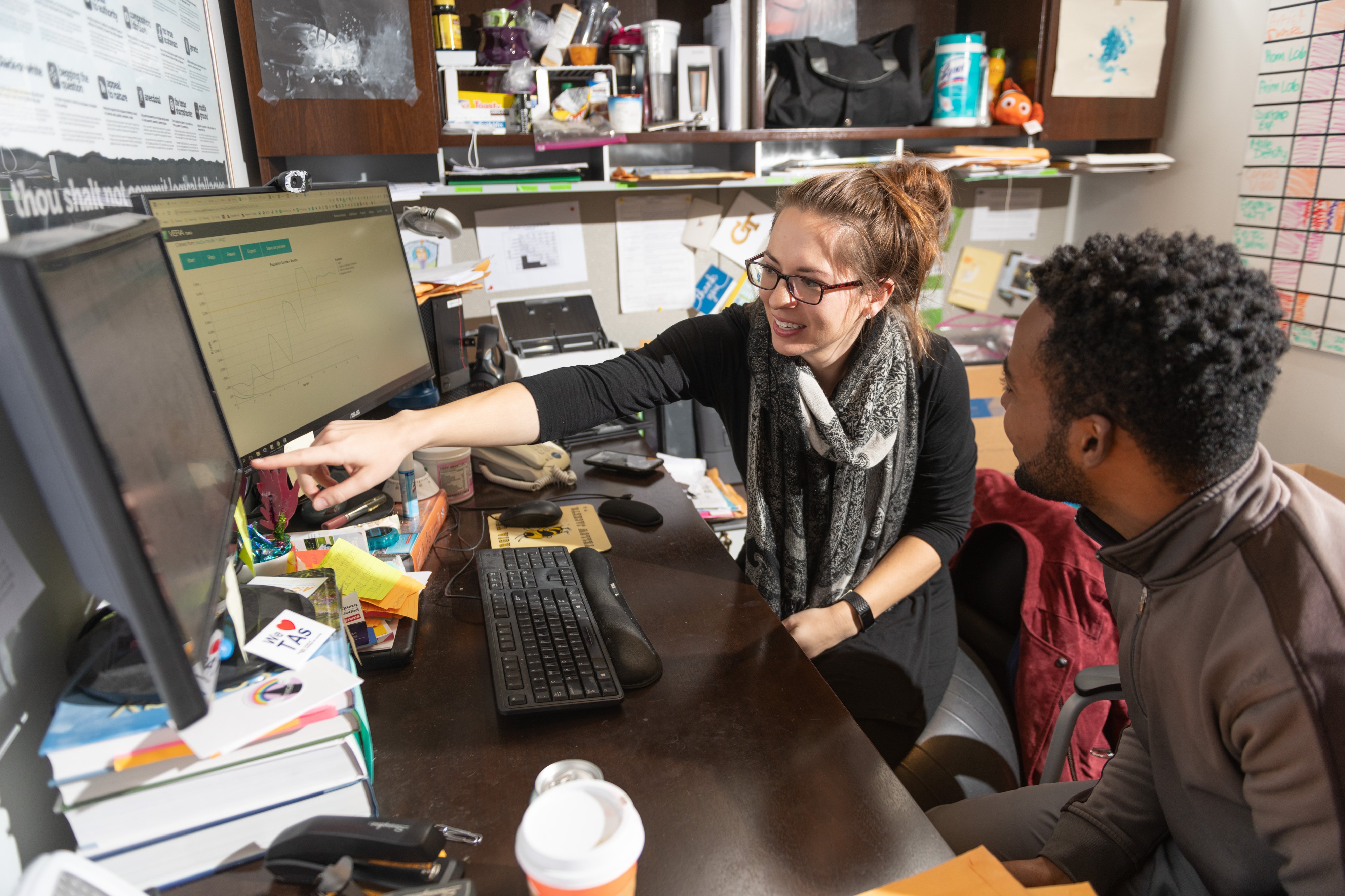 Two Georgia Tech staff members looking at a computer together