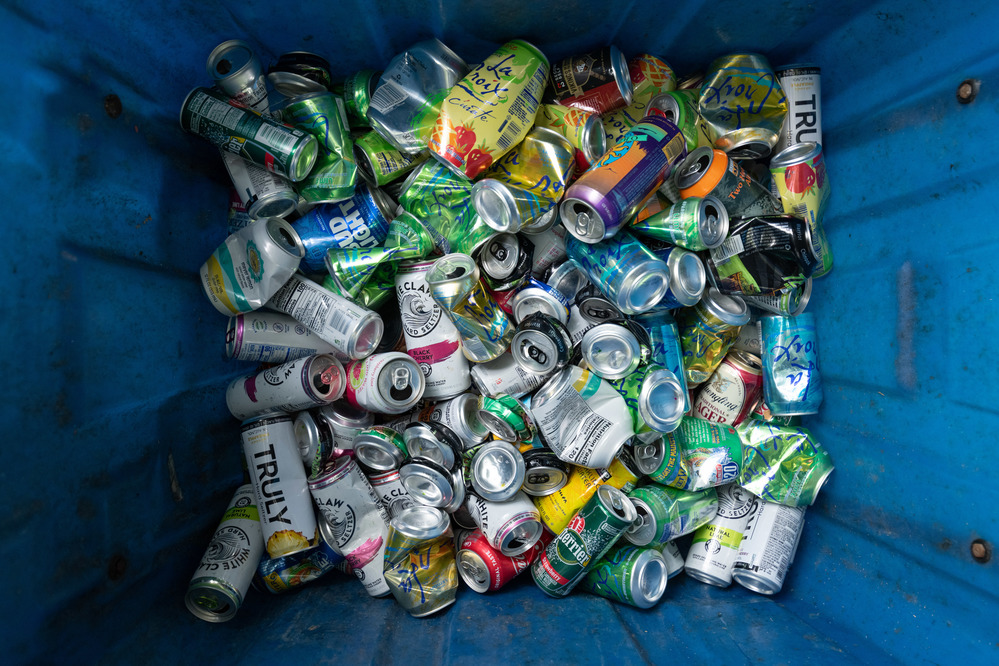 Image of a recycling bin filled with a lot of aluminum cans